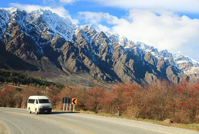 Campervan against backdrop of snowy mountains in New Zealand in winter