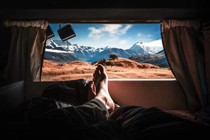 The view from the back window of a campervan into the mountains