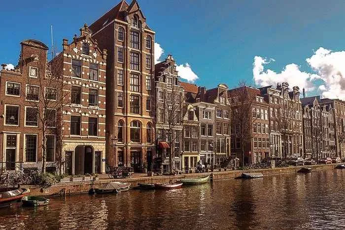 A canal in Amsterdam with tall, narrow buildings - budgets for the Netherlands